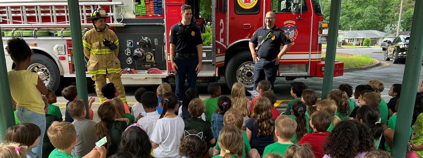 fire truck and firemen visit group of students